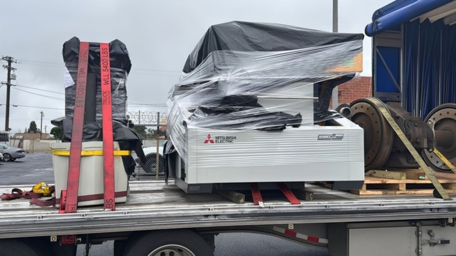 Industrial equipment secured on a flatbed trailer for transportation