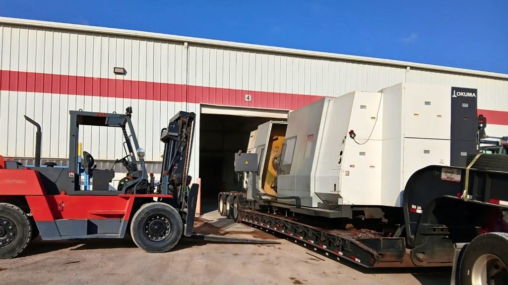 Lowboy trailer hauling tall heavy machinery for freight transport