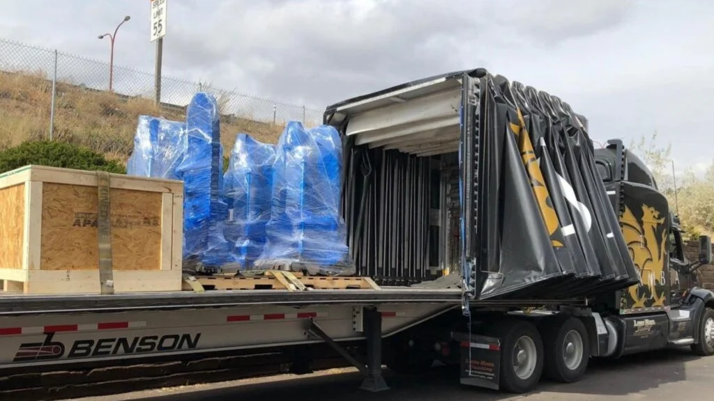 Shared Conestoga With Two Shippers Wooden crate and blue shrink wrapped machinery from different shippers sharing a Conestoga trailer