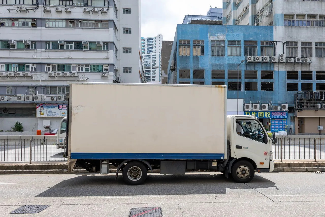 White box truck with a cargo box parked on a city street