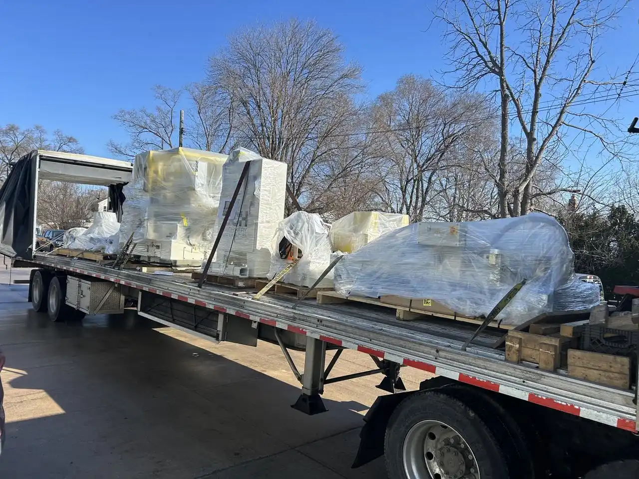 Conestoga Tarp Rolled Forward for Loading Conestoga trailer with the tarp system rolled forward and wrapped machinery on the open deck