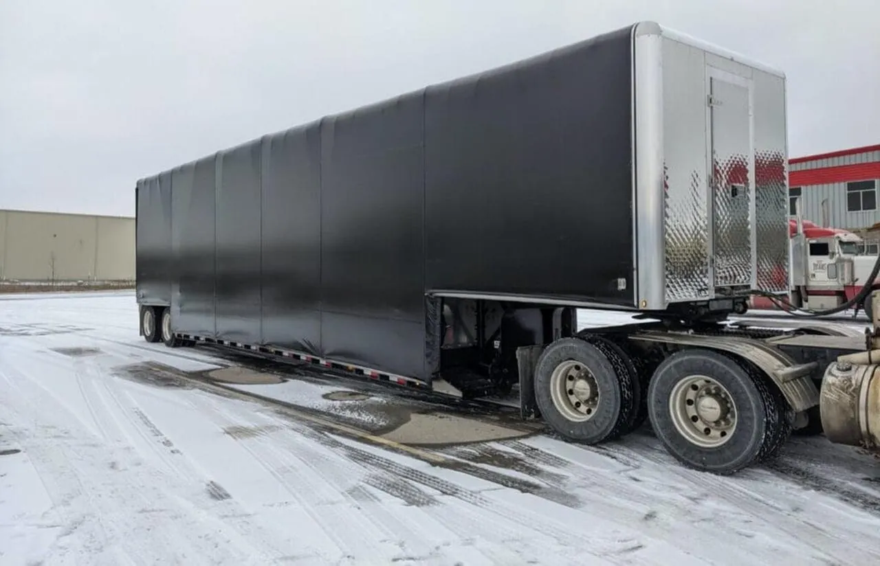 Double drop Conestoga trailer with the rolling tarp fully closed over the low well