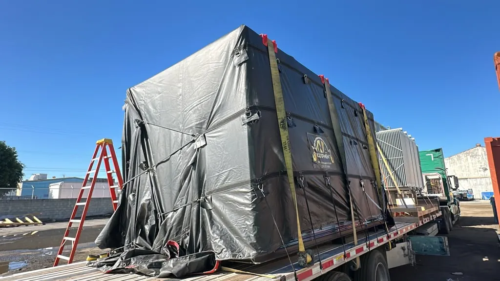 Fully tarped CNC machine crate on a step deck trailer ready to leave for Texas