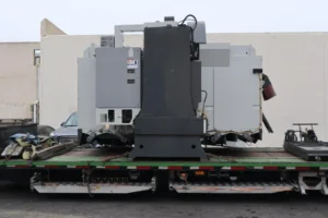 Rear view of a Haas vertical machining center chained on a flatbed