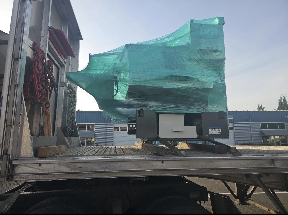 EDM Machine on a Flatbed Green shrink wrapped EDM machine on a flatbed trailer for EDM machine transport from Los Angeles