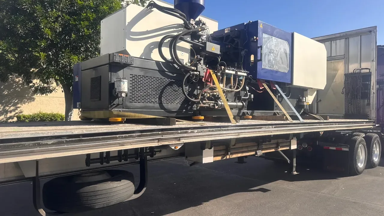 Plastic injection molding machine chained on a flatbed trailer