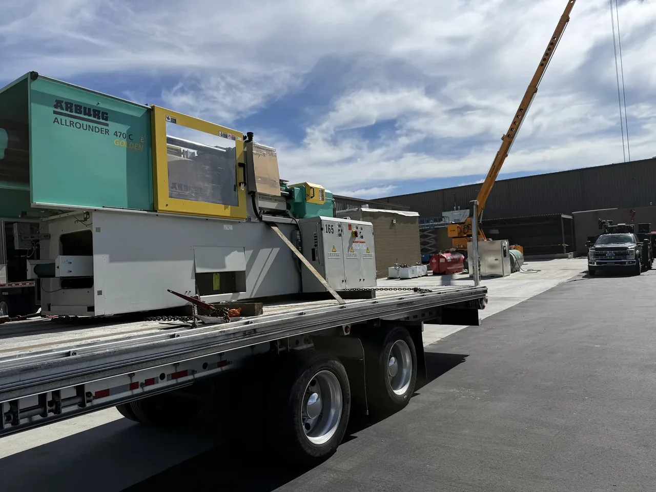 Injection molding machine secured on a flatbed trailer