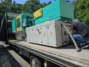 Injection molding machine being loaded on a flatbed