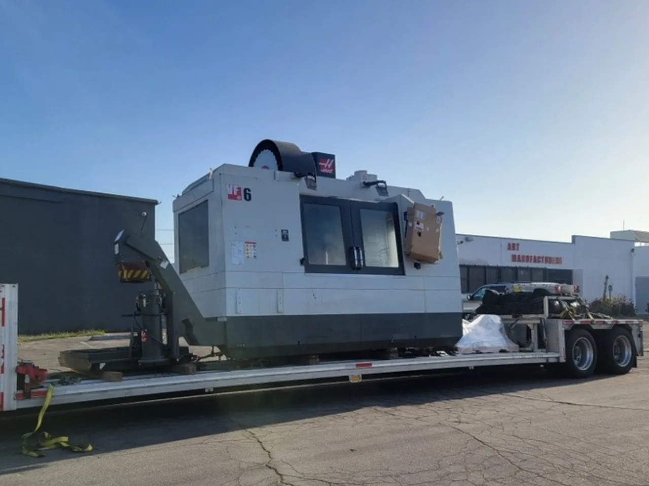Large CNC machining center chained on the lower deck of a step deck trailer