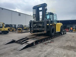 Large forklift on a removable gooseneck trailer