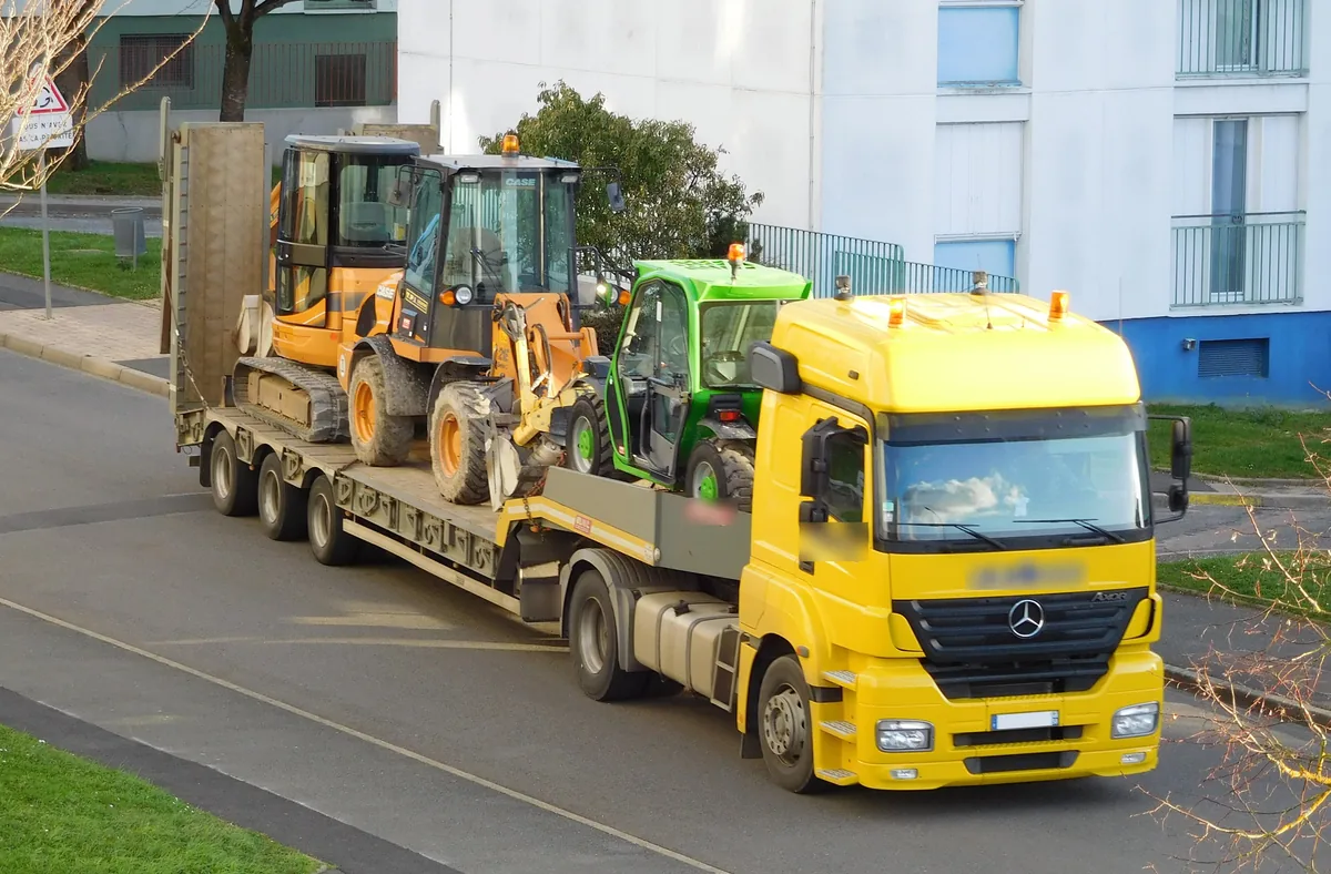 Mini excavator, compact wheel loader and telehandler loaded together on a step deck trailer