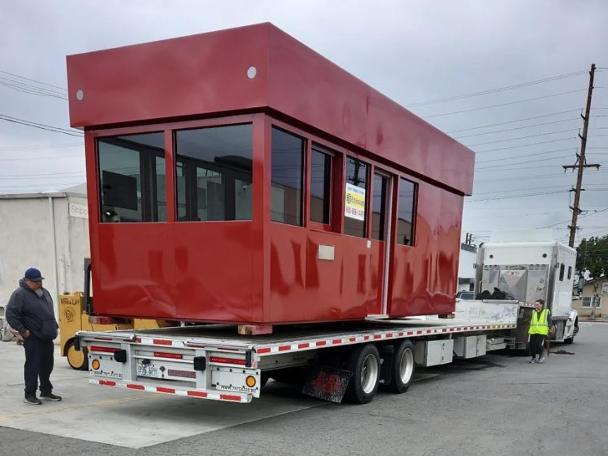 Prefab Modular Booth on a Step Deck Prefabricated modular booth on an open deck step deck trailer