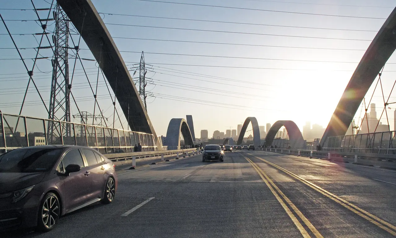 Arches of the Sixth Street Viaduct in Los Angeles with the downtown skyline at sunset