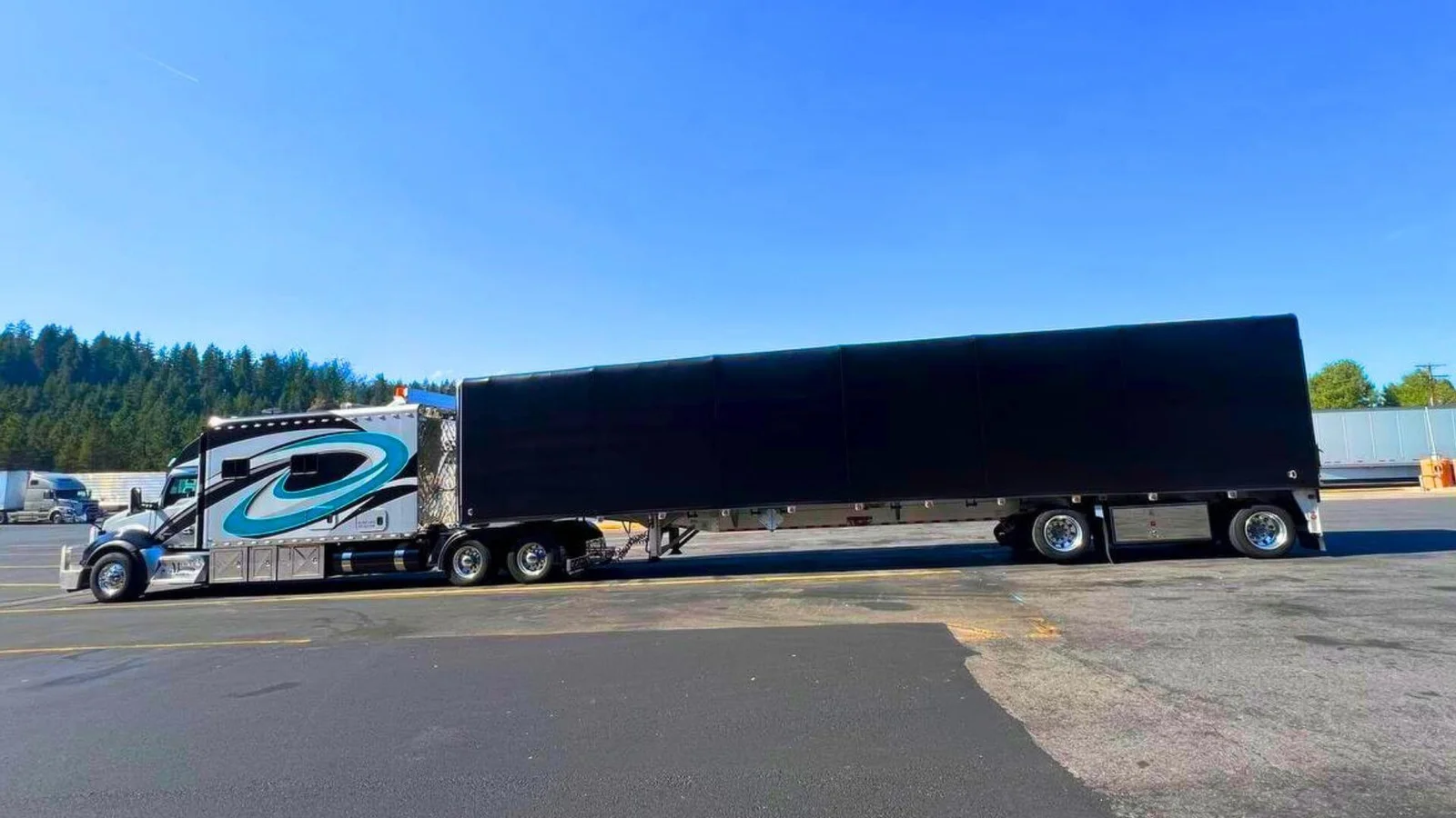Team drivers parked with a loaded Conestoga flatbed in Los Angeles