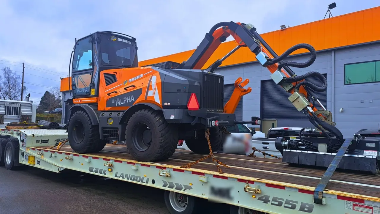 Wheeled excavator with an attachment chained on a traveling axle trailer